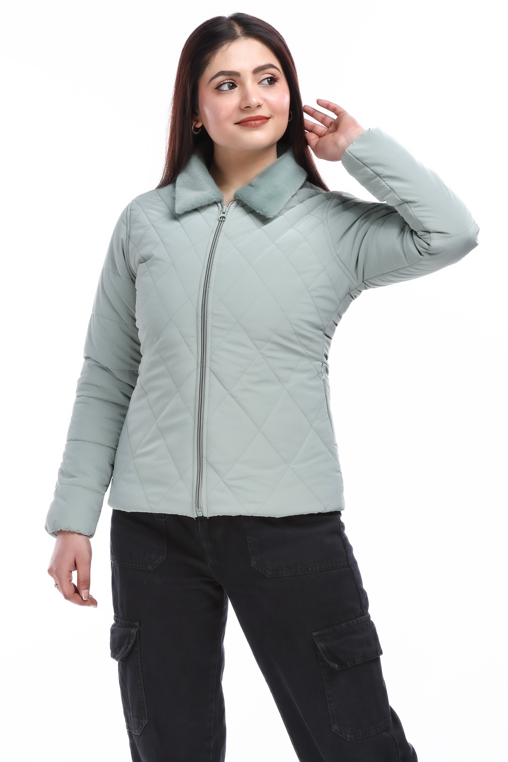 Full-length view of a woman in a blue faux-fur pu jacket and black cargo pants, posing with one hand on her head and looking away.