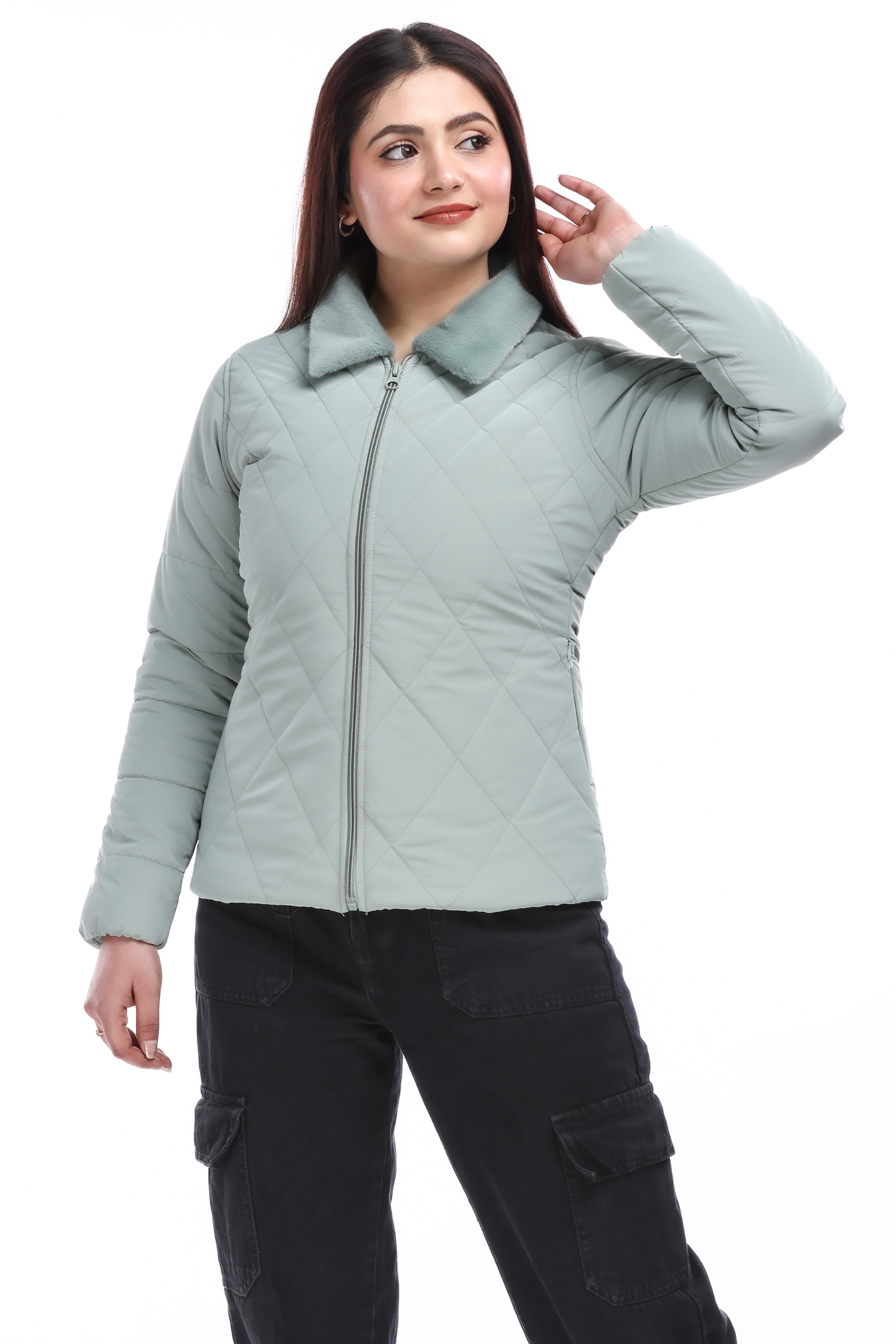 Full-length view of a woman in a blue faux-fur pu jacket and black cargo pants, posing with one hand on her head and looking away.