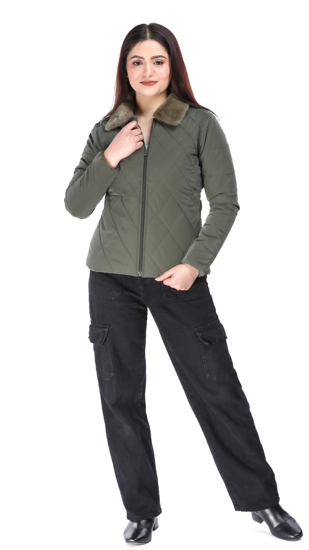 Woman wearing an olive quilted jacket with faux fur collar, paired with black cargo pants and black boots, posing with one hand holding the zipper.