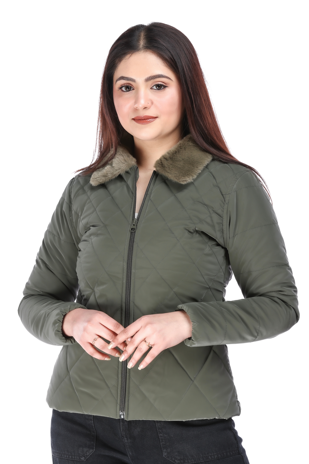 Front view of woman in olive quilted jacket with faux fur collar, standing with hands gently clasped.