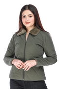 Front view of woman in olive quilted jacket with faux fur collar, standing with hands gently clasped.