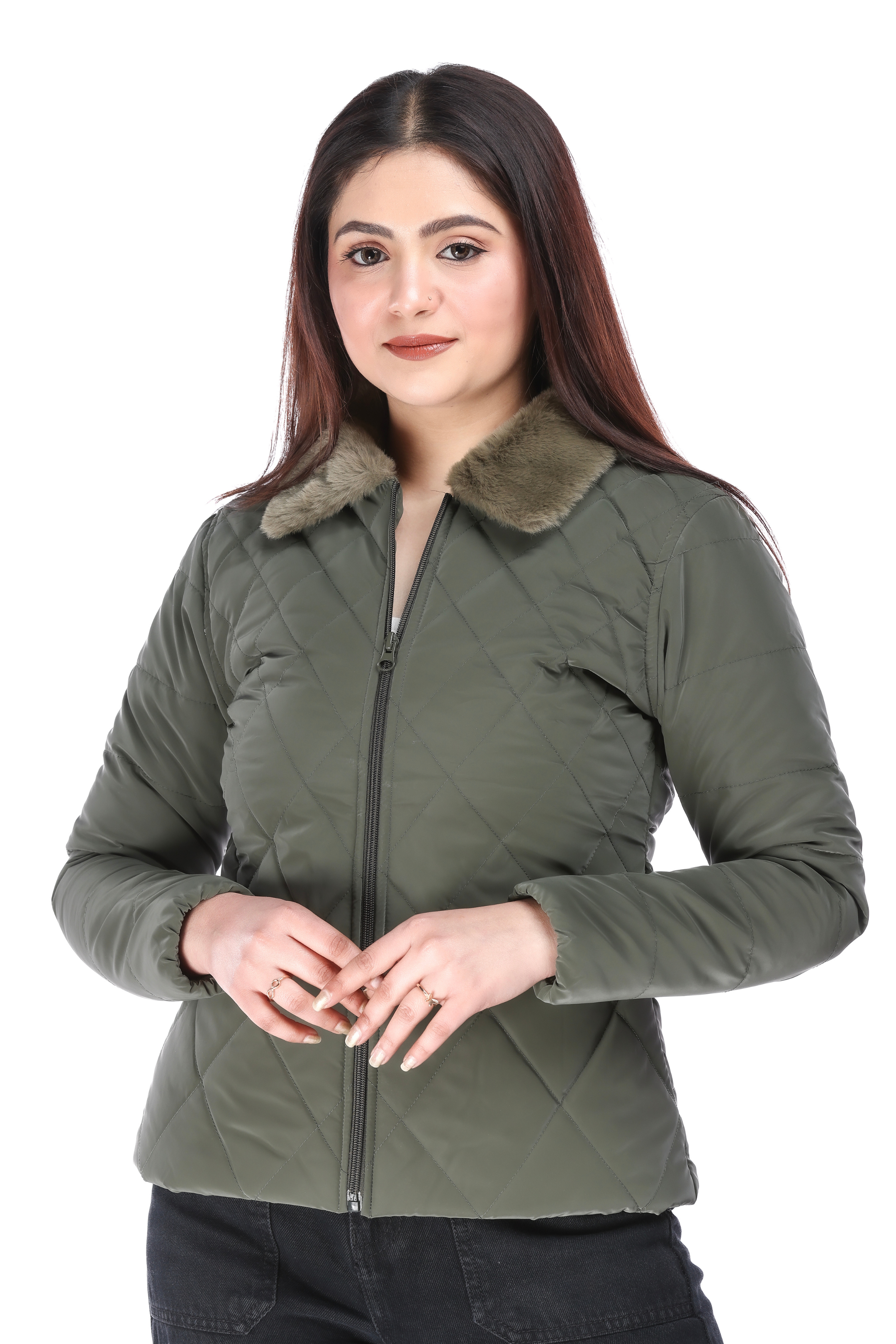 Front view of woman in olive quilted jacket with faux fur collar, standing with hands gently clasped.