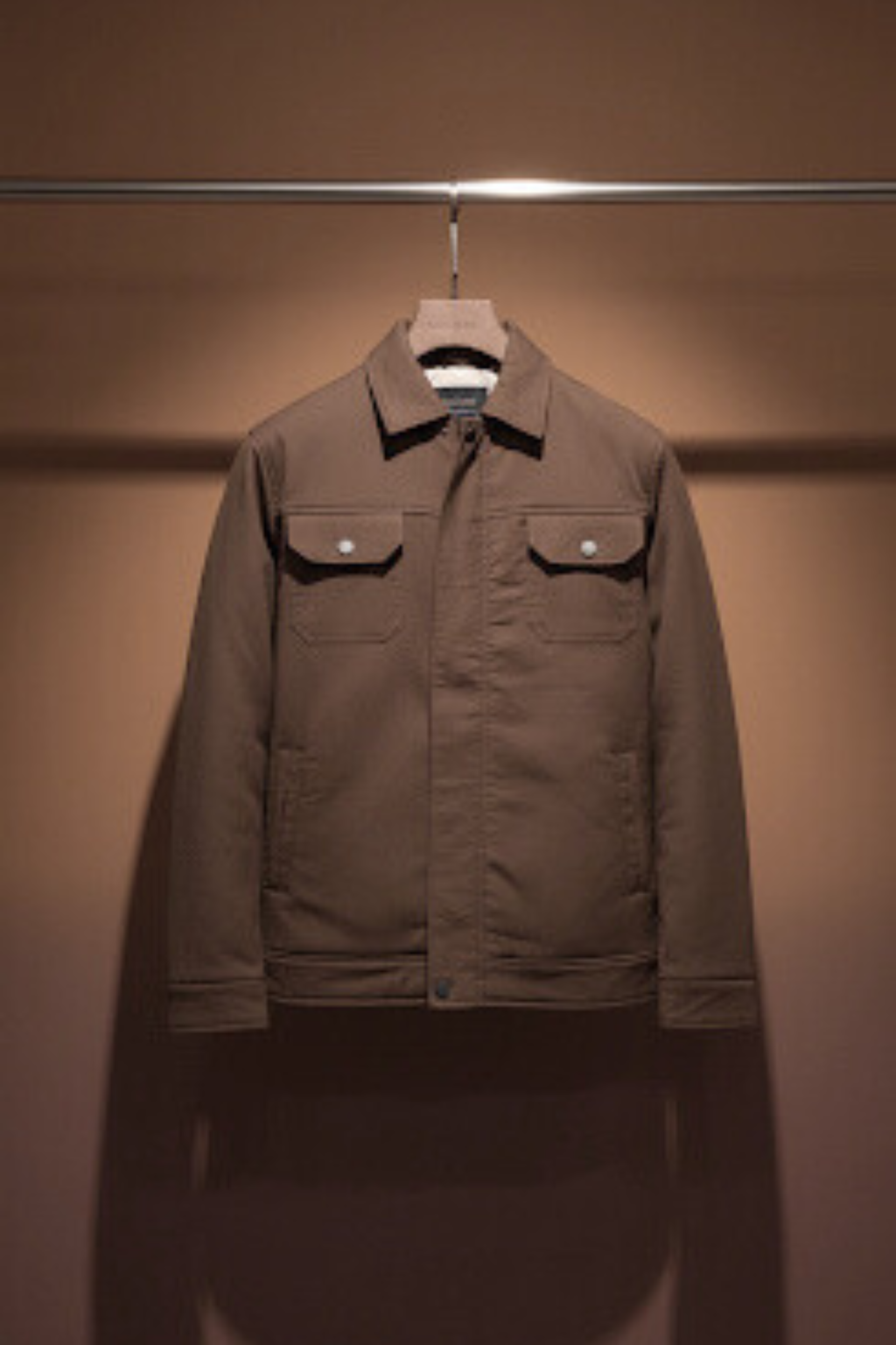 Brown jacket on a hanger against a brown background