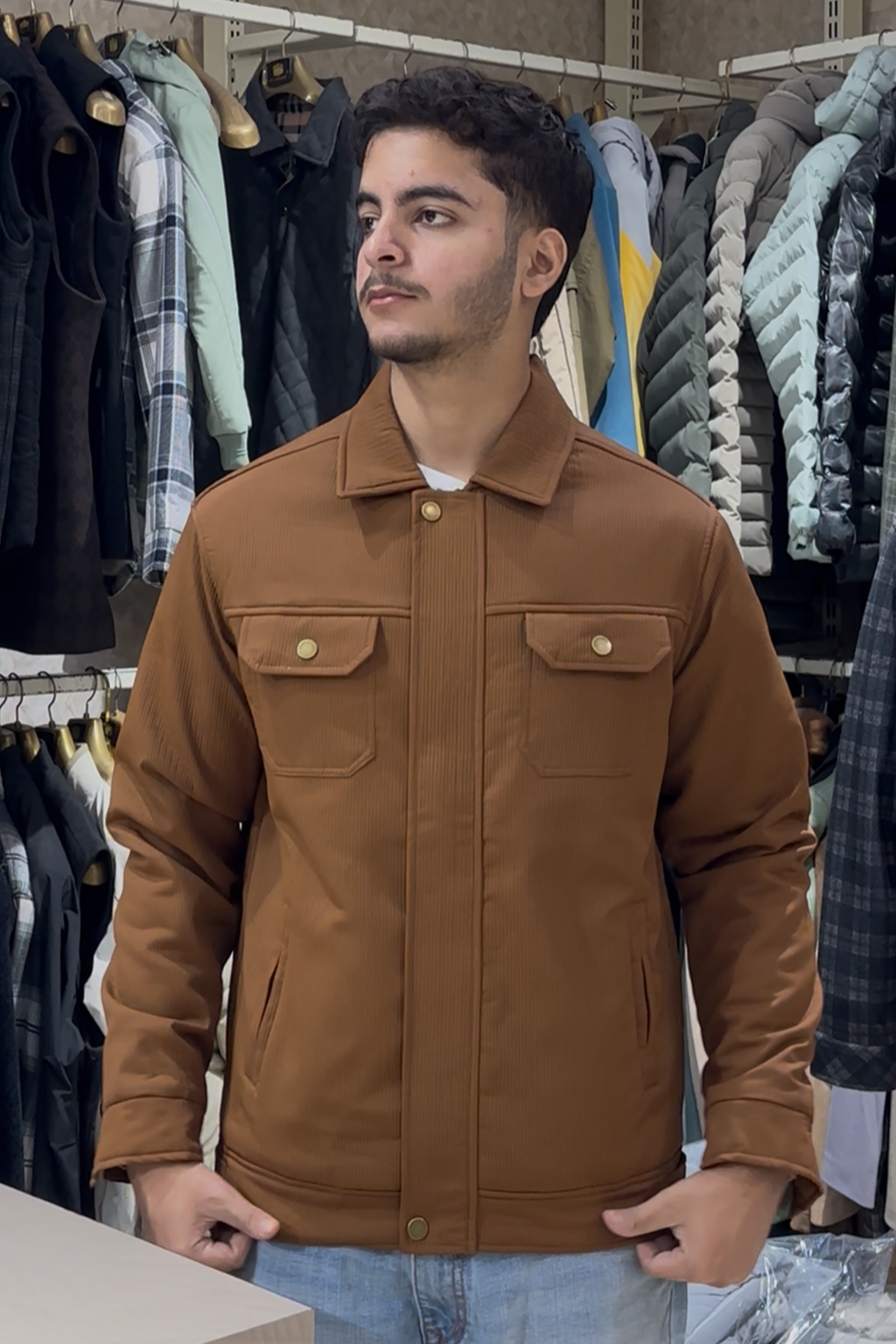 Man wearing a brown jacket in a clothing store