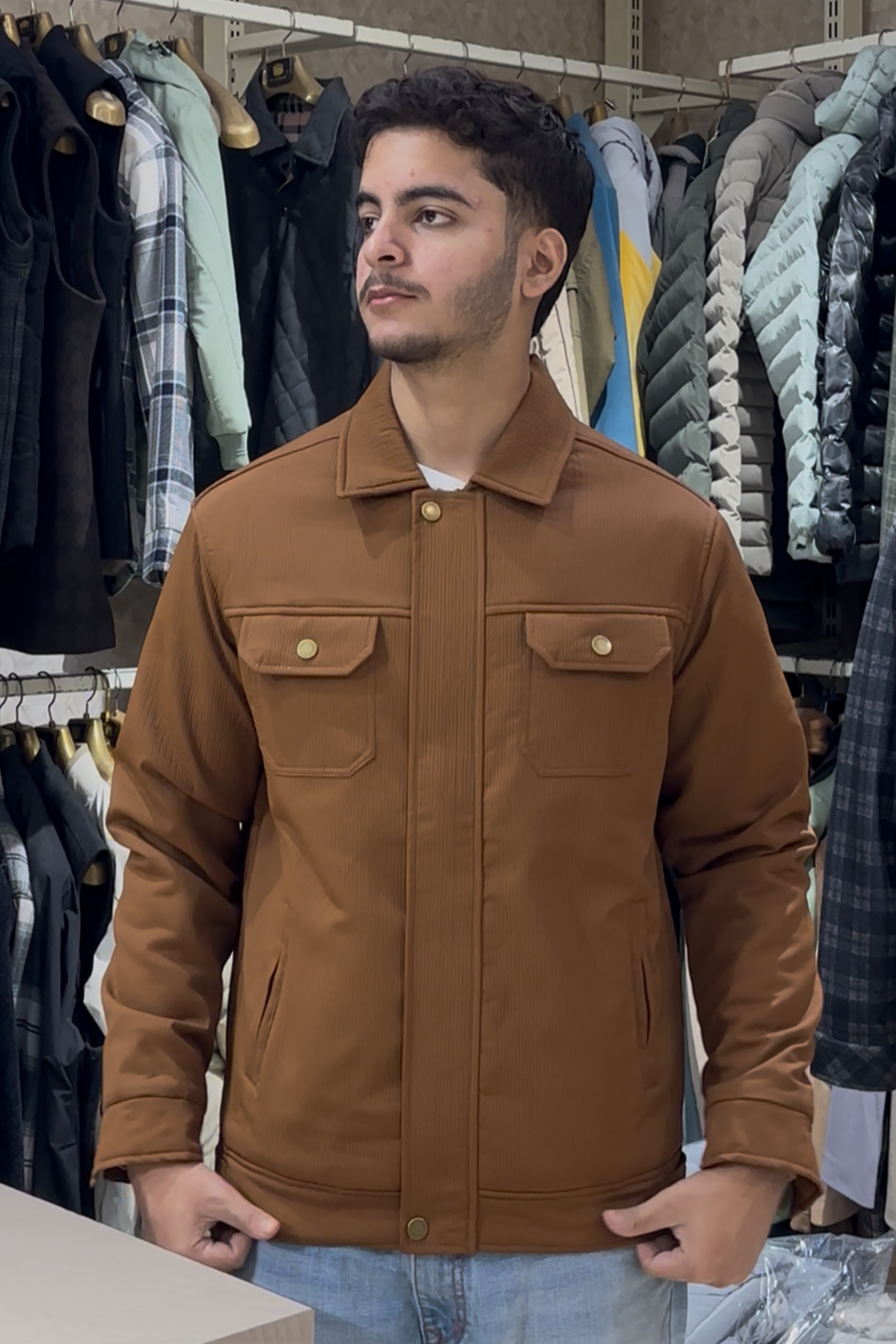 Man wearing a brown jacket in a clothing store