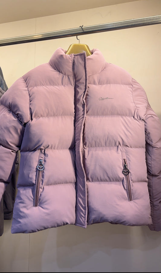 Front view of a light pink cropped heavy quilted Puffer jacket women style, displayed on a hanger with prominent horizontal stitching and zippered pockets