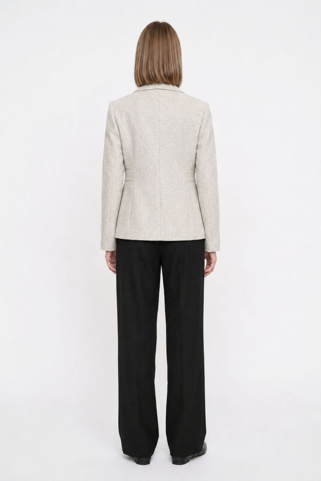Back view of off white short blazer coat showing tailored back seams and welt pocket detail