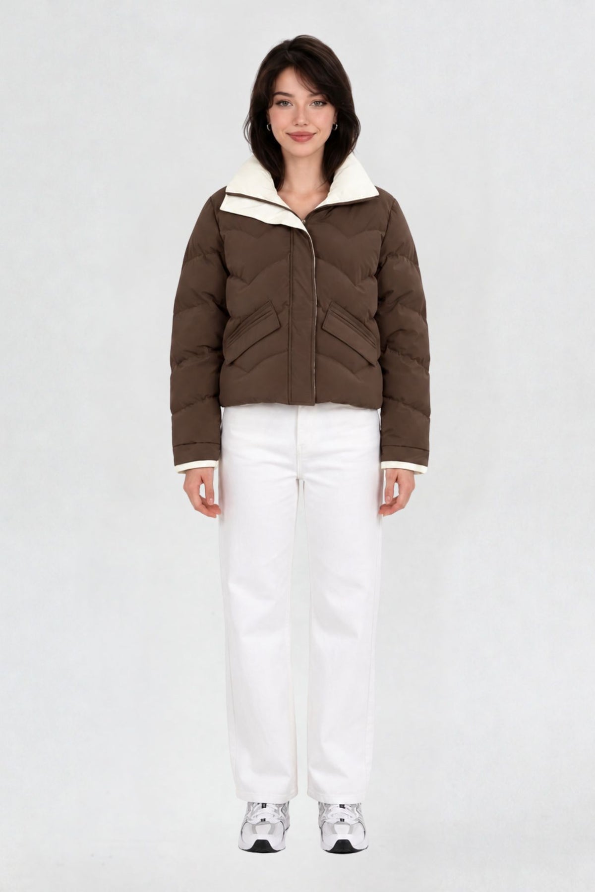 Women's coffee brown puffer jacket, full front view, quilted chevron pattern with cream lining, worn with white jeans and sneakers