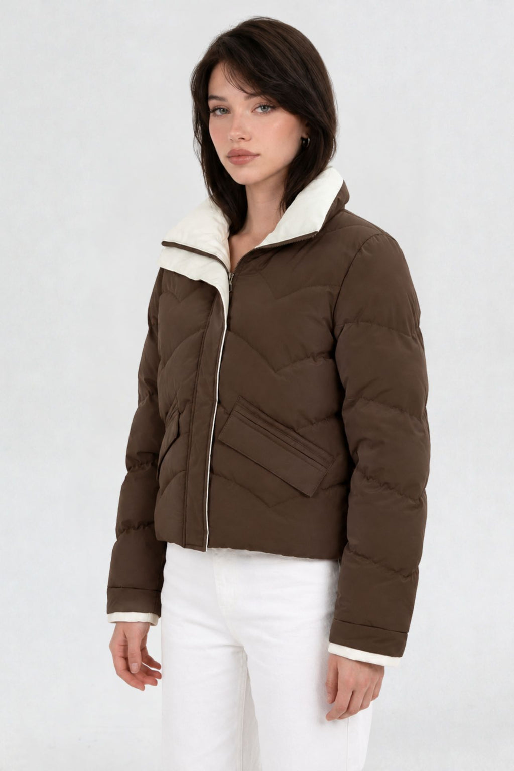 Side view of coffee brown puffer jacket showing cream contrast collar and flap pocket detail