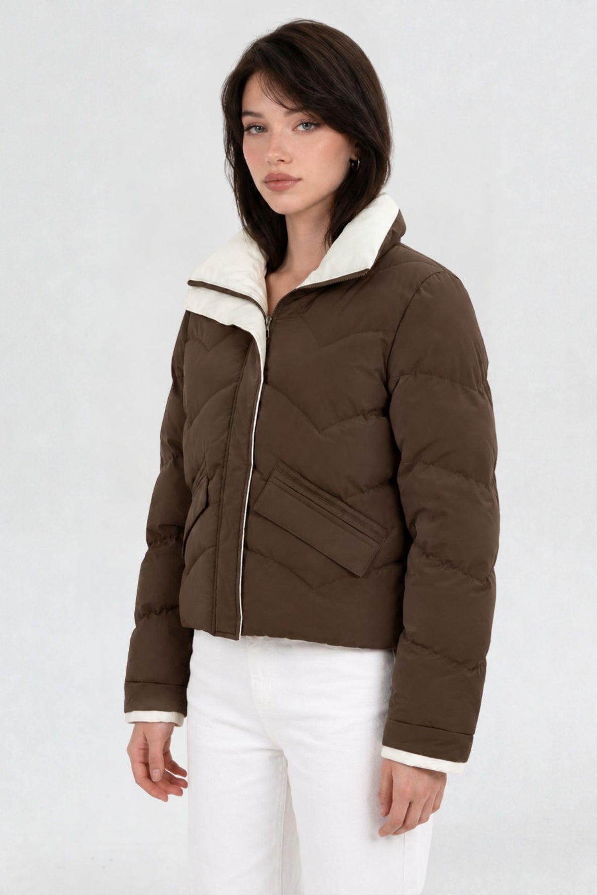Side view of coffee brown puffer jacket showing cream contrast collar and flap pocket detail