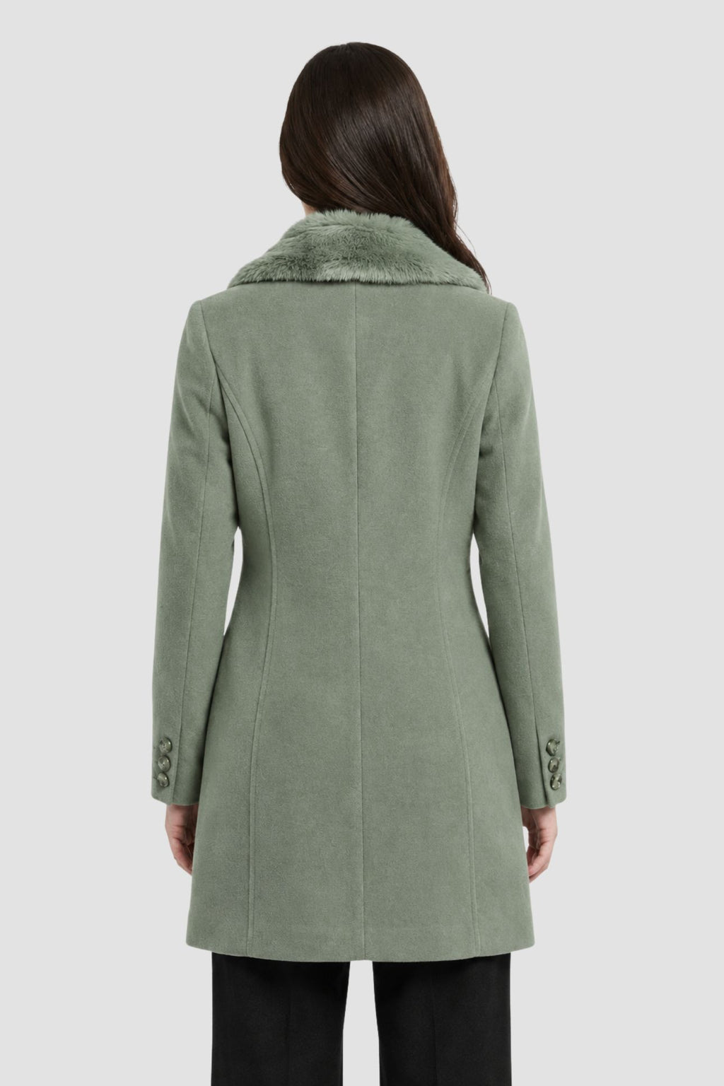 Back view of pista green faux fur overcoat showing tailored back seams and button cuff detail