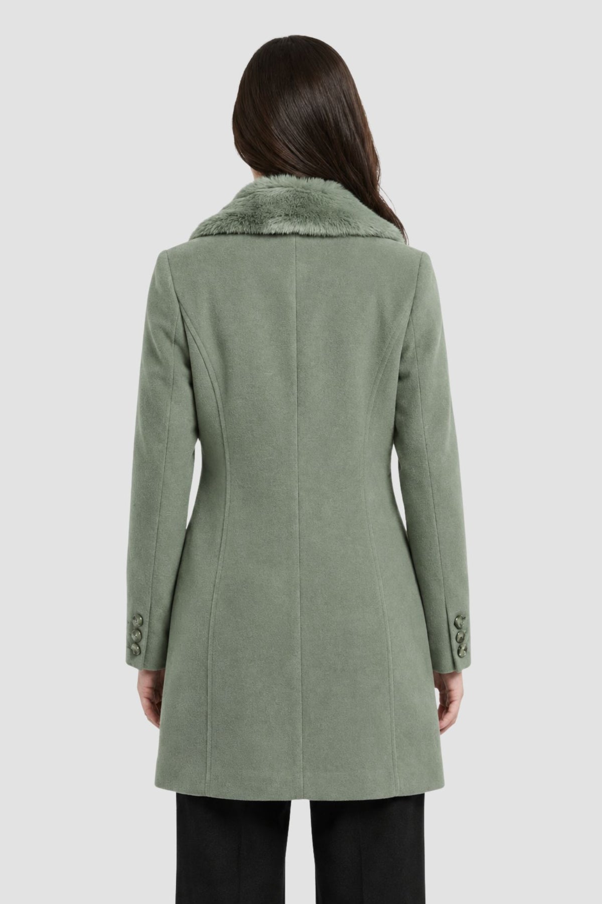 Back view of pista green faux fur overcoat showing tailored back seams and button cuff detail