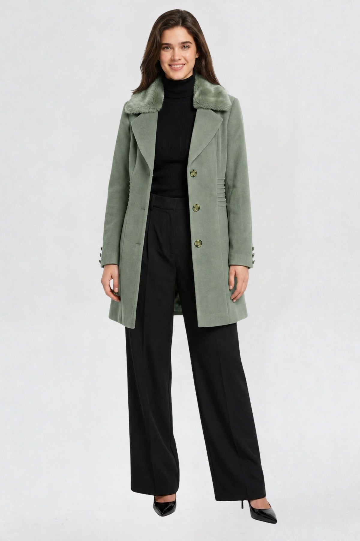 women's pista green faux fur overcoat, front view, faux fur collar and button closure, styled with black turtleneck and trousers