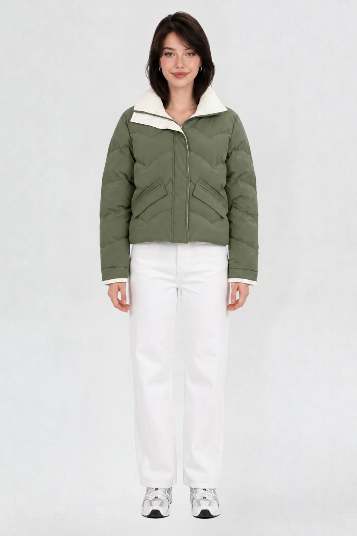 Women's pista green puffer jacket, full front view, quilted chevron pattern with cream lining, worn with white jeans and sneakers